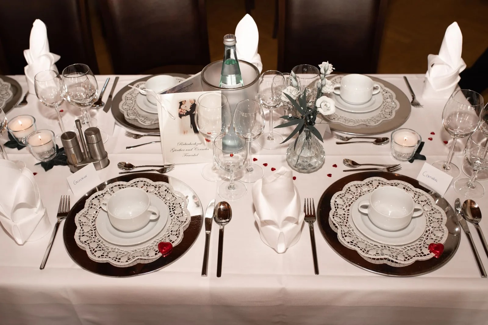 Festliches Gedeck mit Gläsern, Serviette und Blumenschmuck