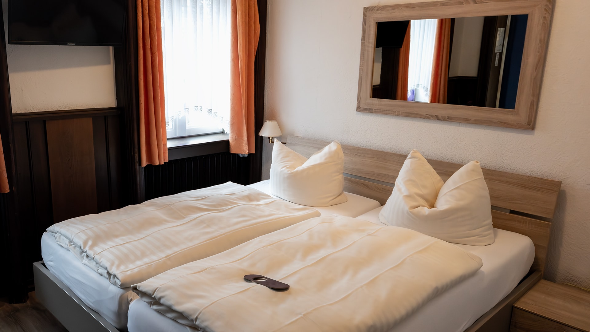 Helles Doppelzimmer mit bezogenem Bett und Sitzgelegenheit