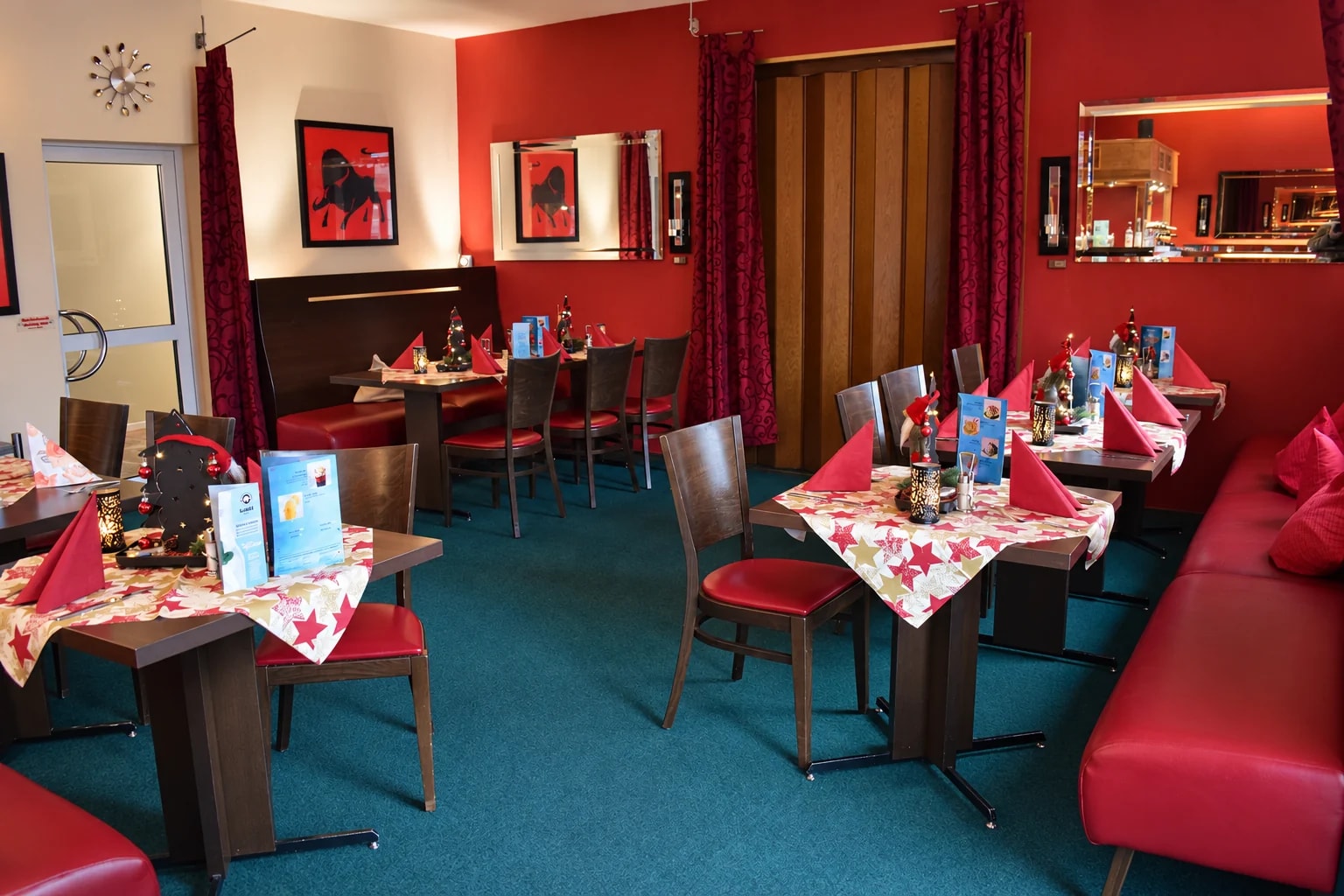 Gastraum des Steak House mit gedeckten Tischen und roten Sitzbänken