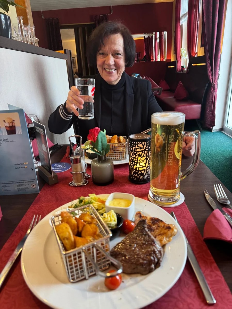 Ein Gast beim gemeinsamen Essen mit Steaks und Beilagen im Steak House