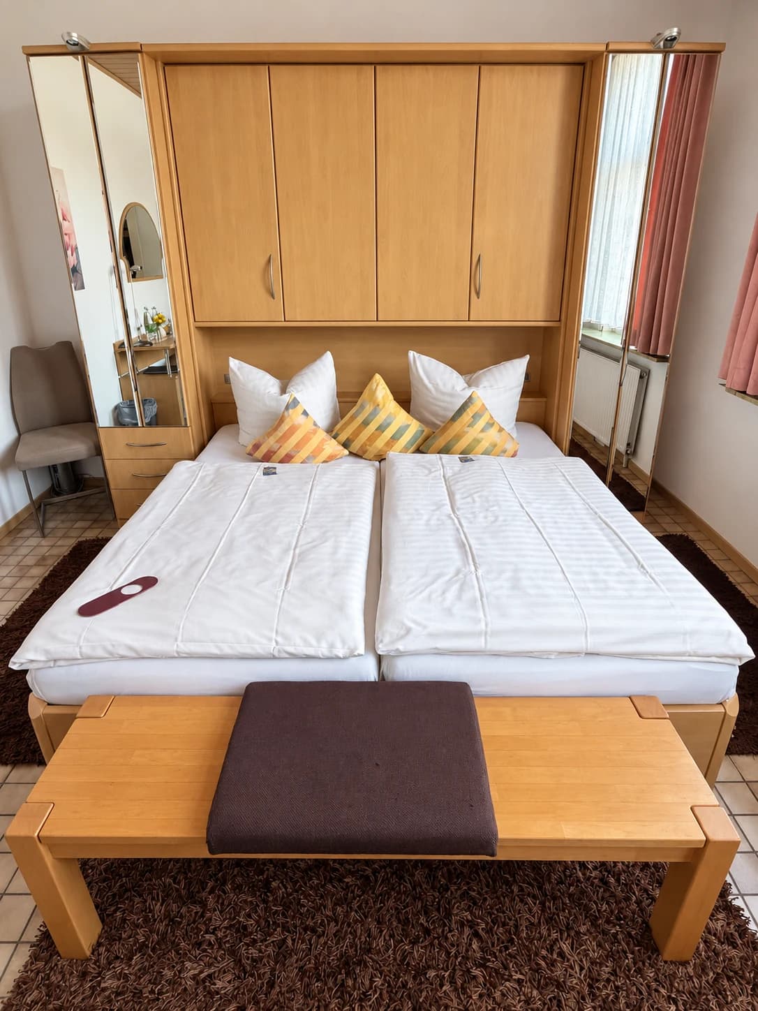 Doppelzimmer mit zwei nebeneinanderliegenden Betten und warmen Holzmöbeln