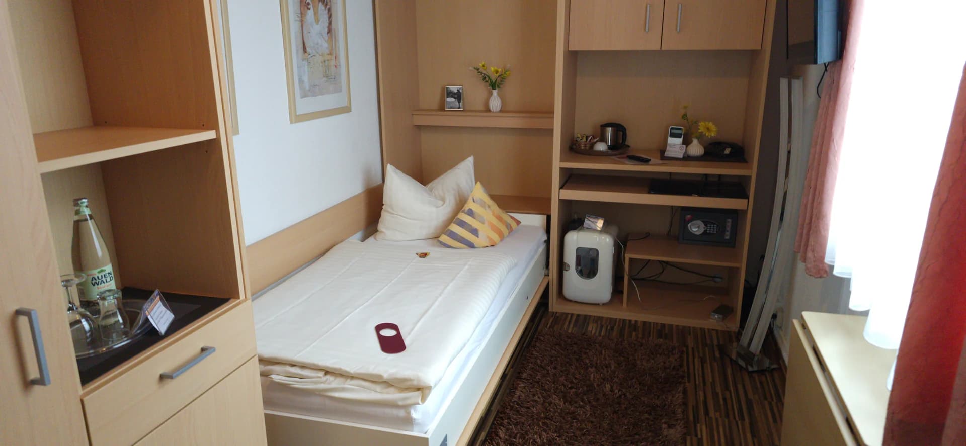 Einzelzimmer mit Einzelbett und hellem Holzmobiliar